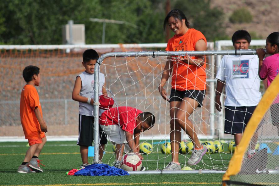 A group of young children playing soccer outdoors